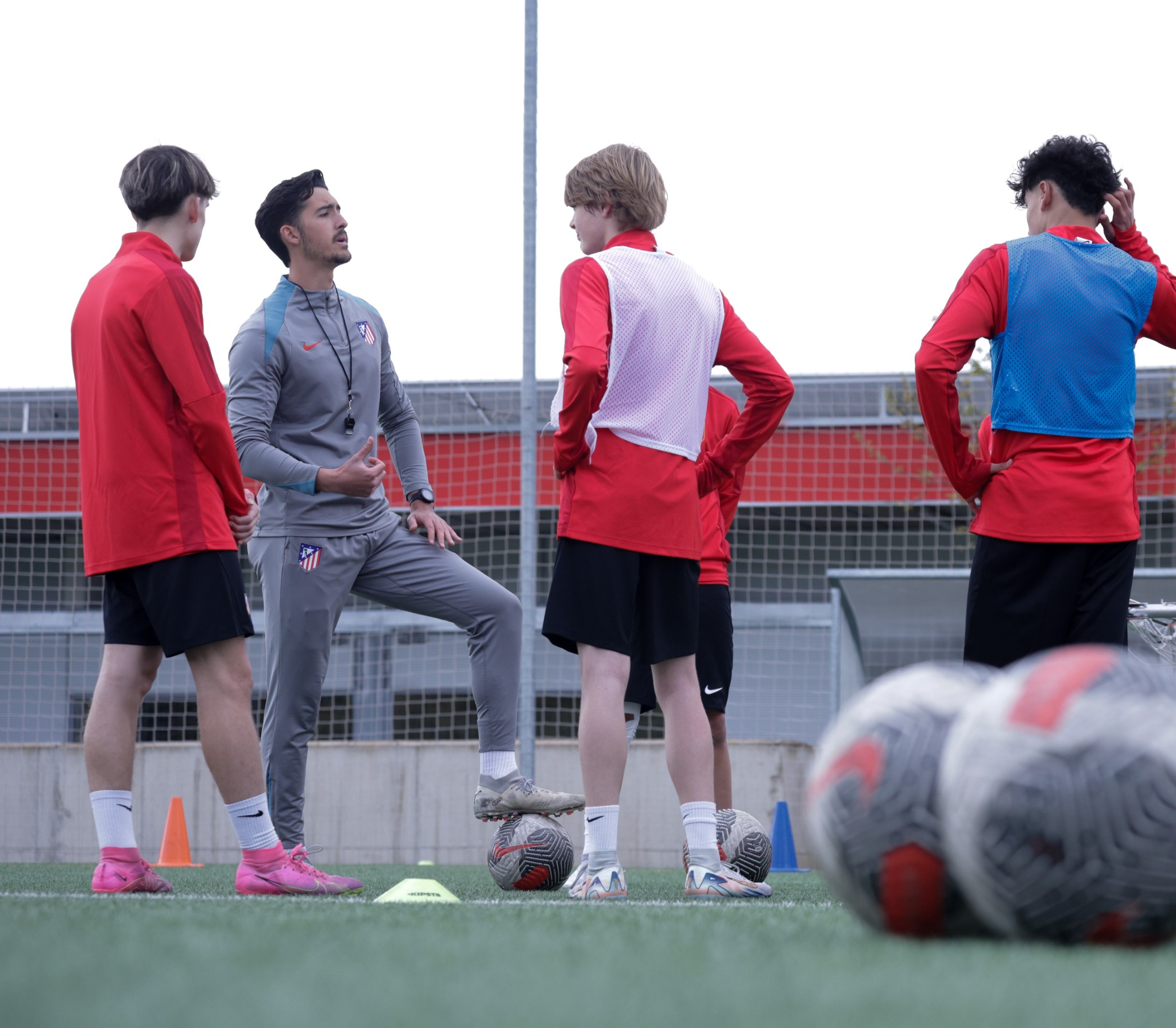 An Atlético coach explaining a training exercise to a group of players