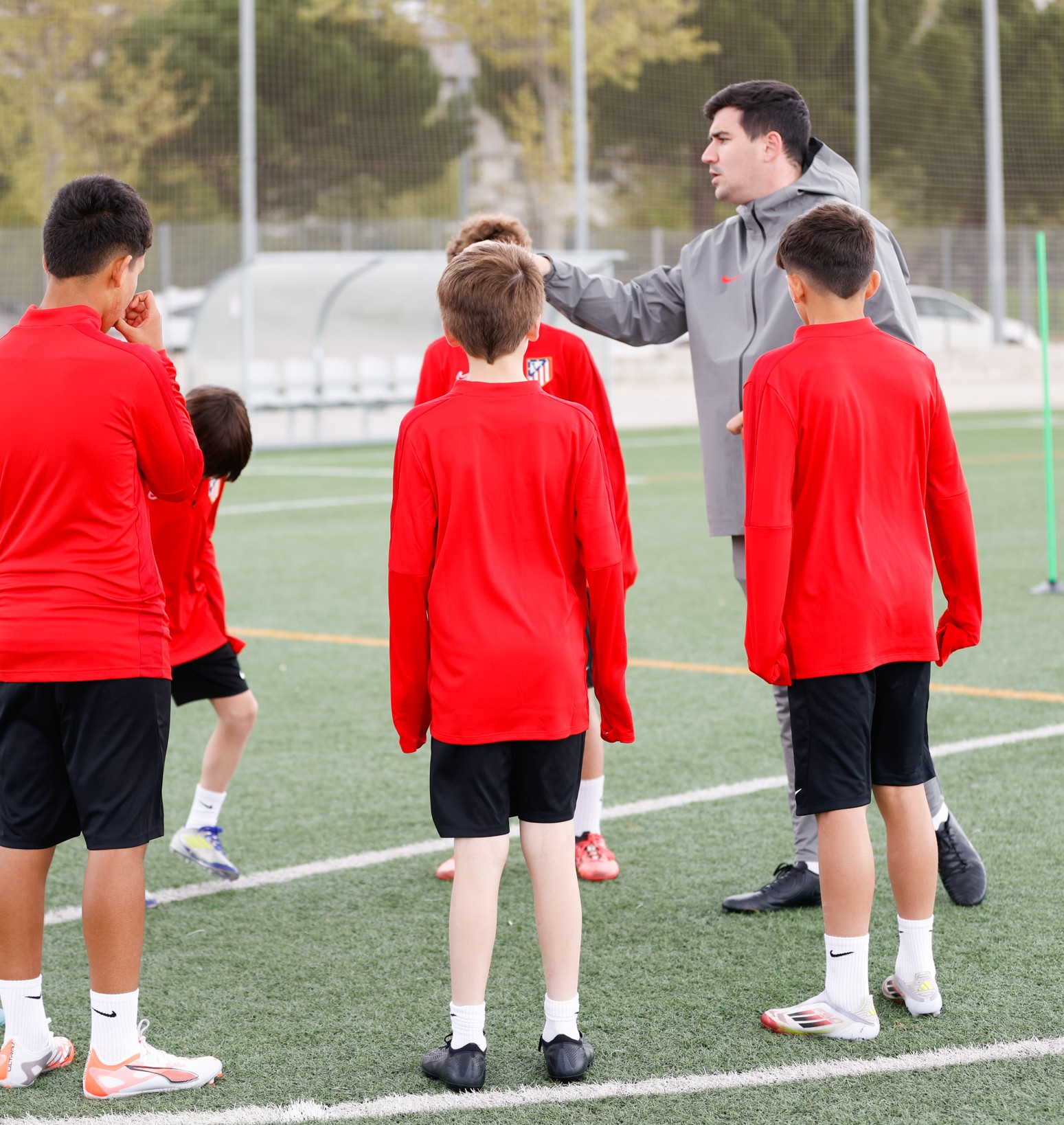 An Atlético coach speaking with players during a training session