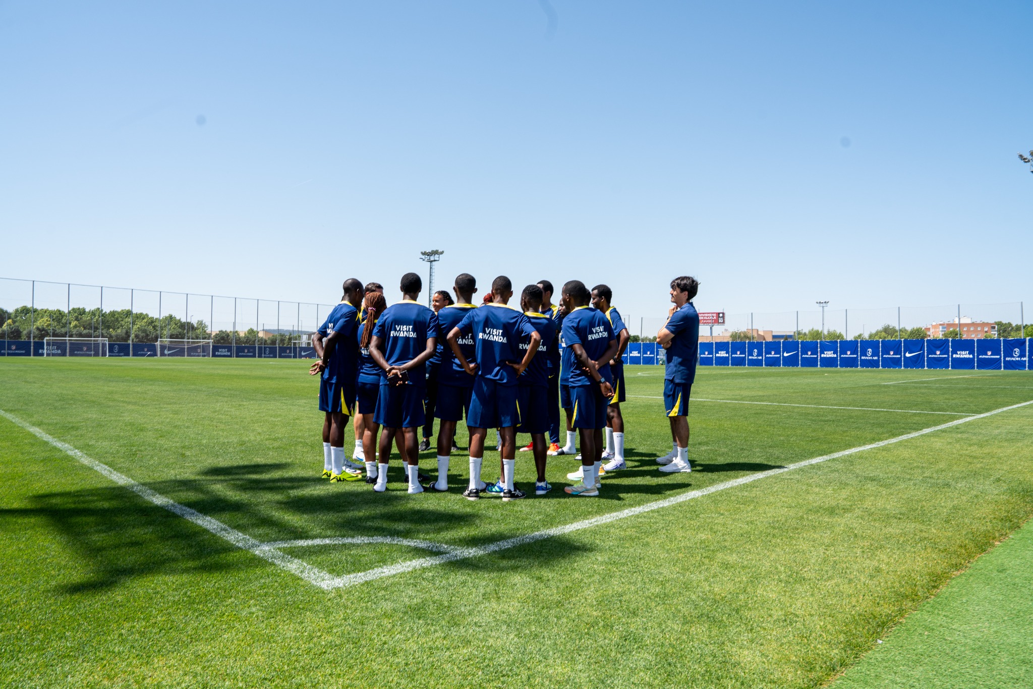 A visiting coach-experience group gathered on the training pitch